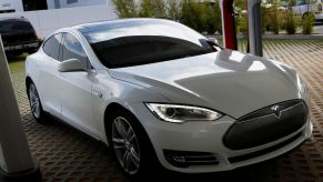 A used 2013 Tesla Model S all-electric full-size luxury sedan at a charging station