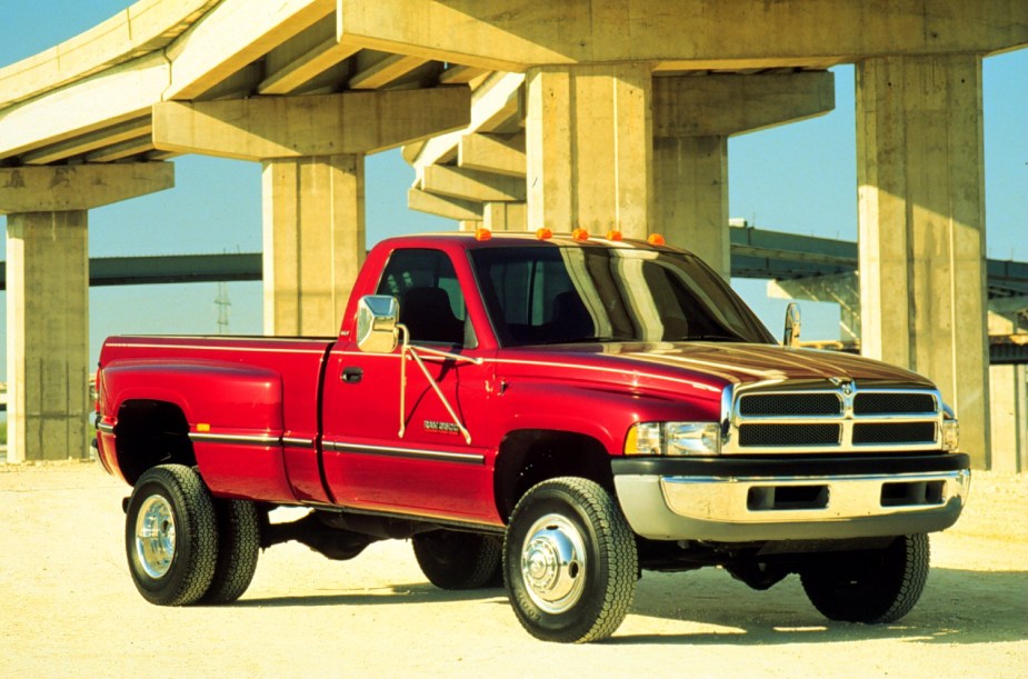 Red 2nd Gen Cummins Dodge Ram 3500 parked beneath a bridge for a publicity photo.