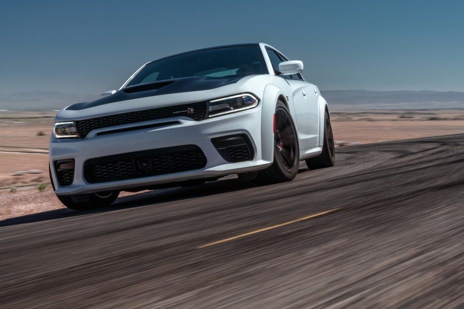 A 2022 Dodge Charger V8 Scat Pack Widebody tears up a corner on a track. 