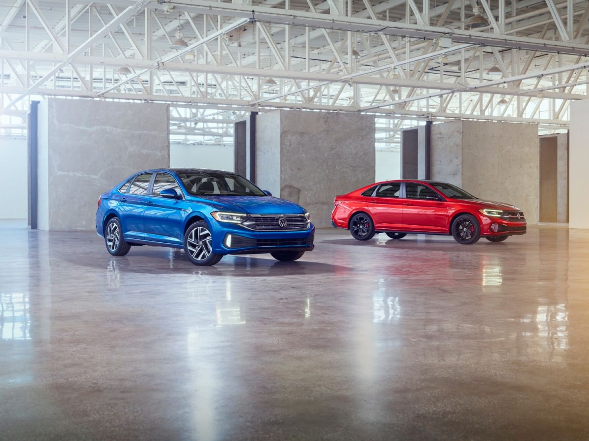 A Volkswagen Jetta and Jetta GLI on display in a warehouse.