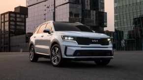 A white Kia Sorento Plug-In Hybrid midsize plug-in hybrid SUV is parked.