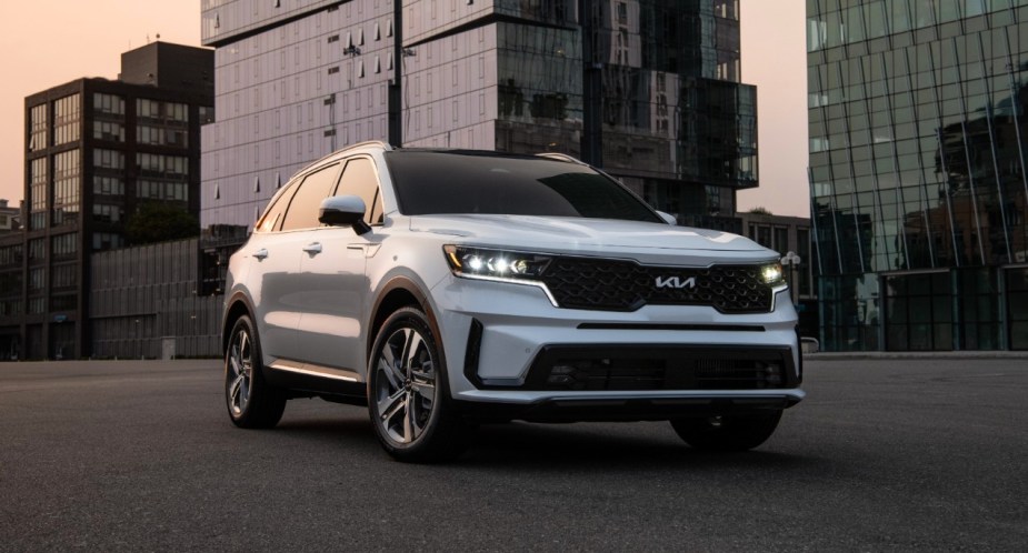 A white Kia Sorento Plug-In Hybrid midsize plug-in hybrid SUV is parked. 