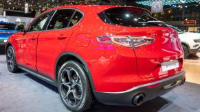 A red 2023 Alfa Romeo Stelvio on display at an auto show.