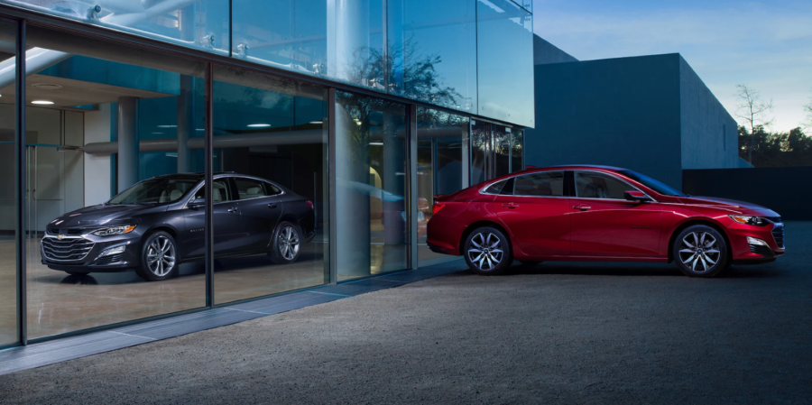 2023 Chevrolet Malibu midsize sedan models in gray and red separated by glass panels