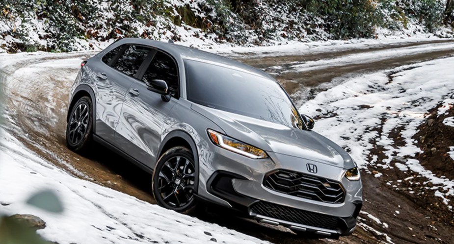 A gray 2023 Honda HR-V subcompact SUV turning on a snowy dirt road. 