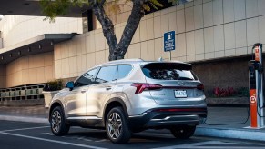 A gray 2023 Hyundai Santa Fe Plug-In Hybrid midsize plug-in hybrid SUV is parked and charging.