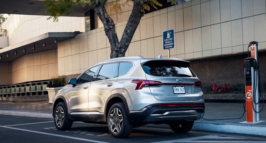 A gray 2023 Hyundai Santa Fe Plug-In Hybrid midsize SUV is charging. 