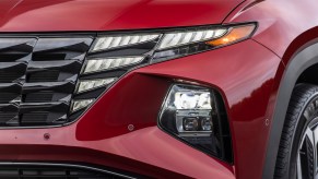 A red 2023 Hyundai Tucson headlight, which is one of the best compact plug-in hybrid SUVs.