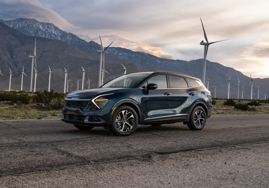 The 2023 Kia Sportage Hybrid parked in front of a wind farm.