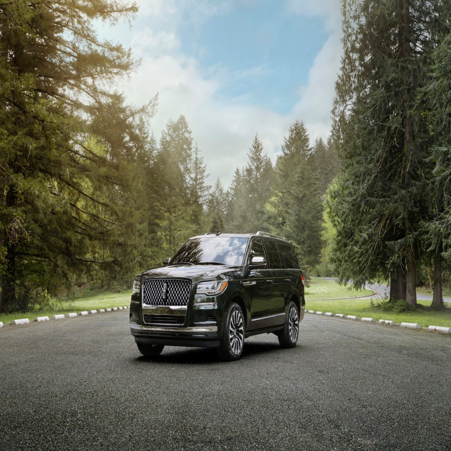 A black 2023 Lincoln Navigator parked outdoors in a wooded area.