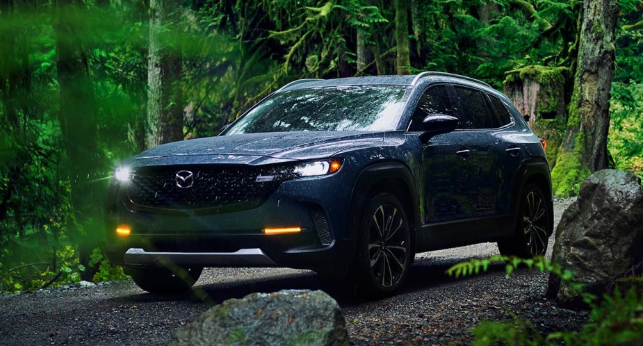 A blue 2023 Mazda CX-50 small SUV is parked off-road. 