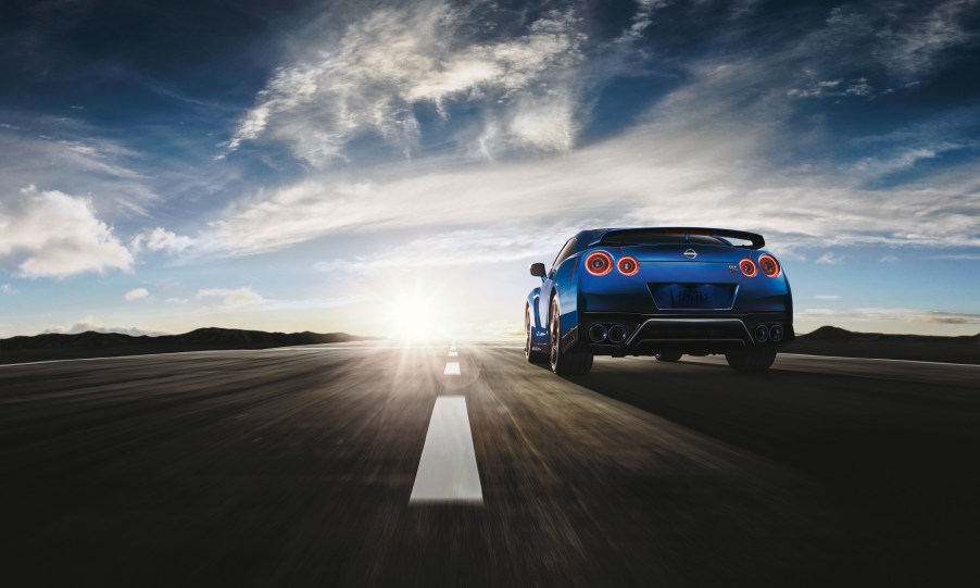 The Nissan GT-R blasts down a track straight, showing off its rear styling.