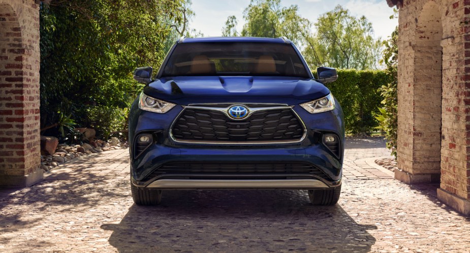 A blue 2023 Toyota Highlander Hybrid midsize hybrid SUV is parked. 