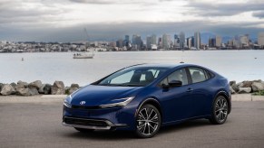 A 2023 Toyota Prius parked in front of a body of water.