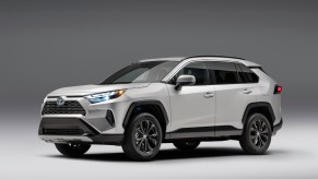 A silver 2023 Toyota RAV4 Hybrid parked in a black and white room