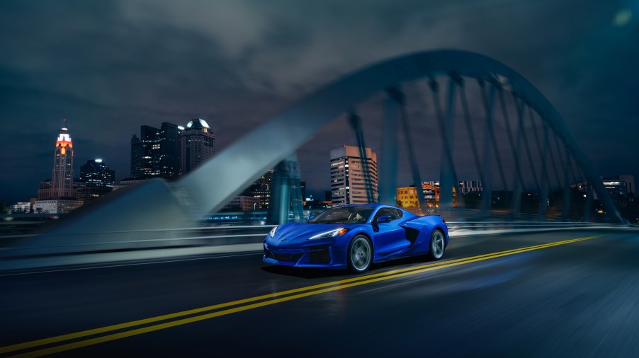 A new Corvette drives across a bridge in the city.