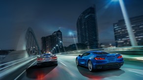 The new 2024 Chevrolet Corvette E-Ray blasts across a city bridge in a pair.