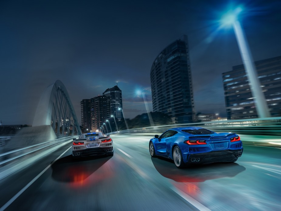 The new 2024 Chevrolet Corvette E-Ray blasts across a city bridge in a pair. 