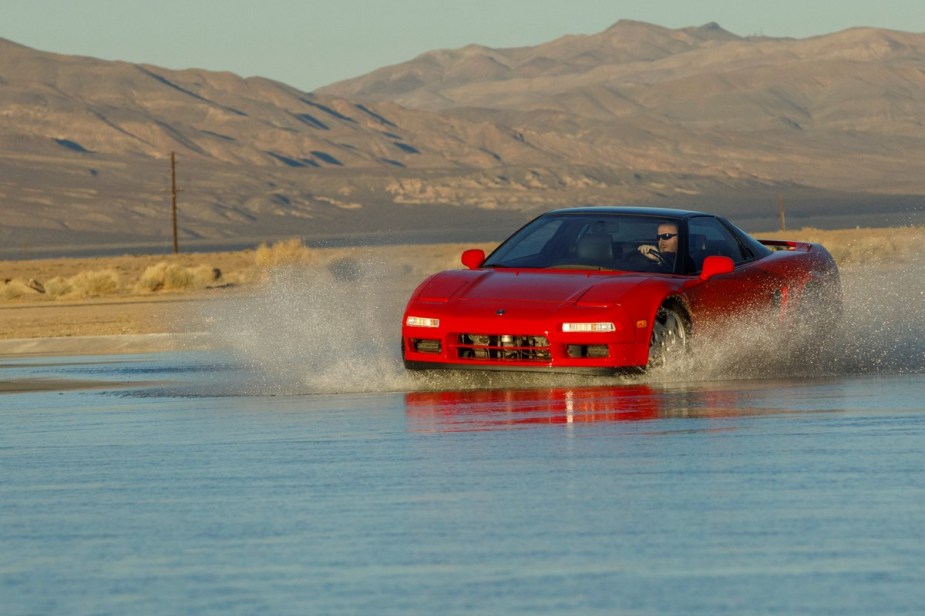 A first-generation Acura NSX driving through water