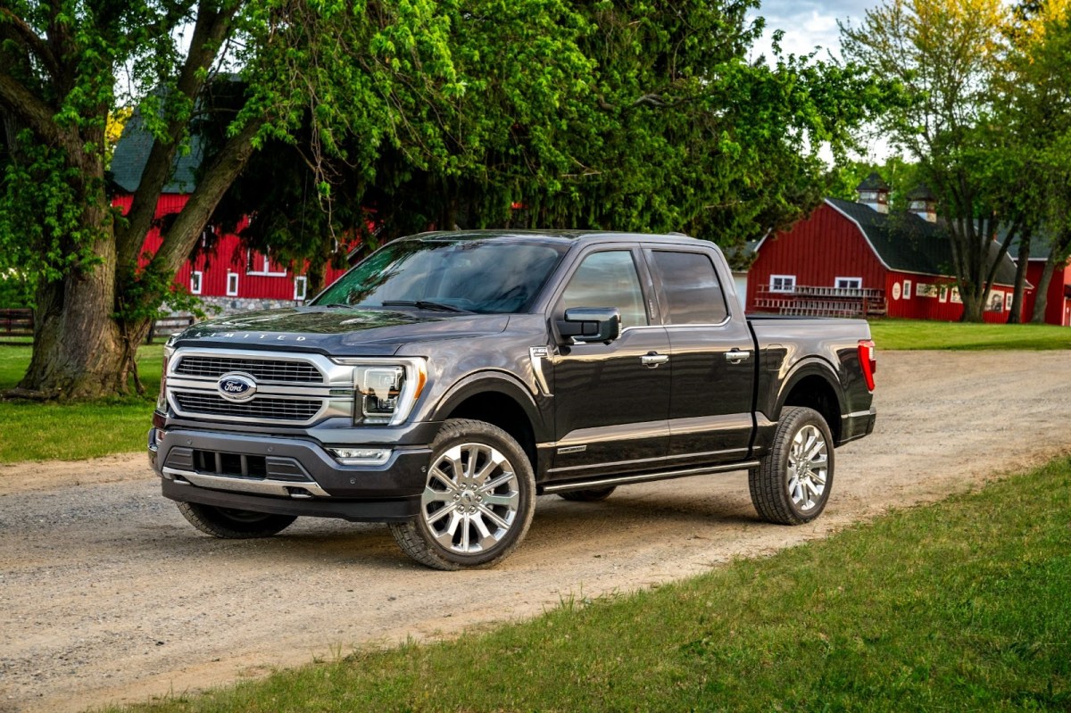 A Ford F-150 parked on a dirt road near  a barn