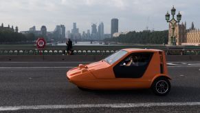 A Bond Bug three-wheeler converted EV crossing Westminster Bridge in London, United Kingdom (U.K.)