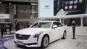 A white Cadillac CT6 plug-in hybrid (PHEV) plugged into a charging station at Auto Shanghai 2017