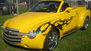 A yellow Chevy SSR pickup truck with flames on its side.