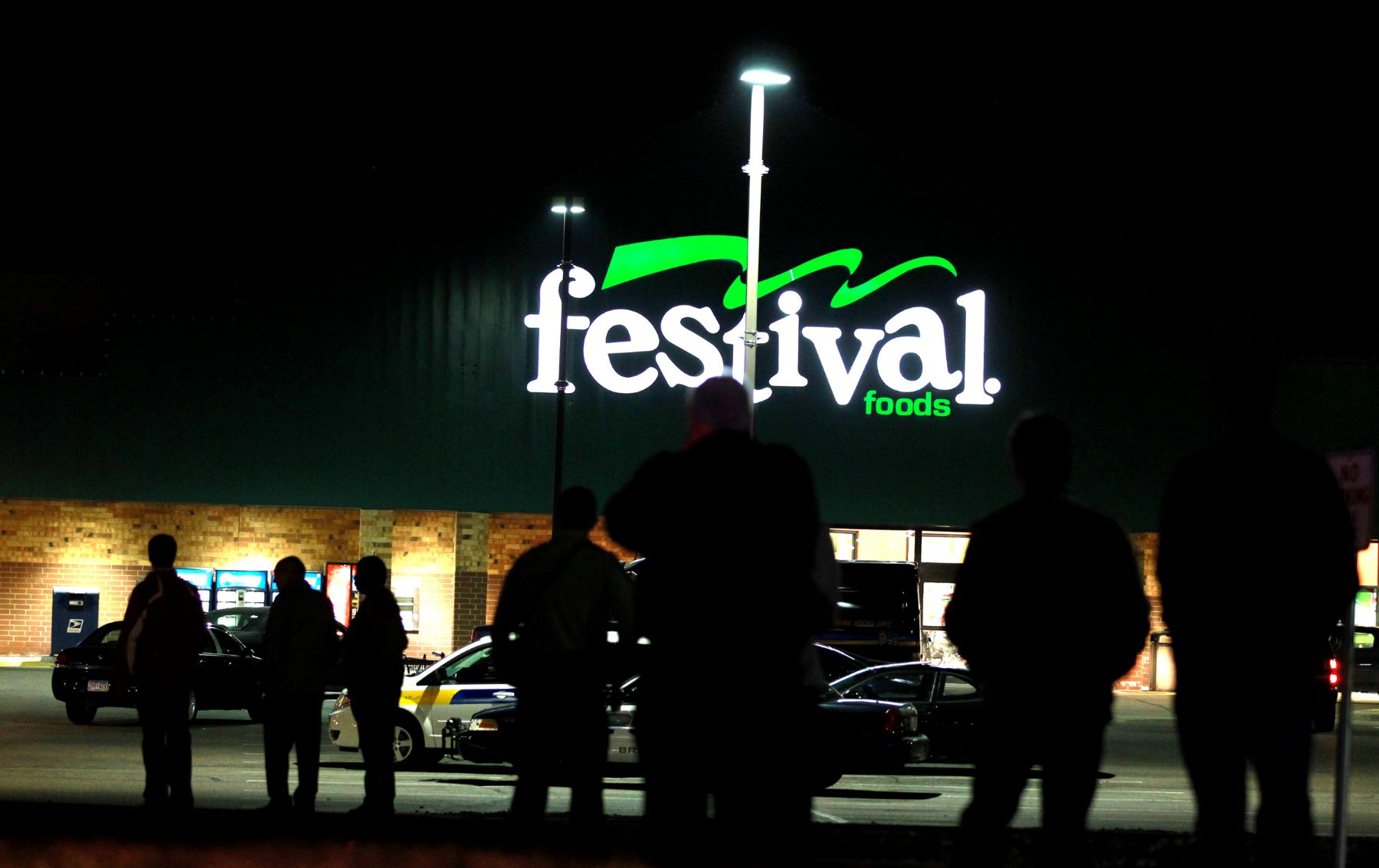 A Festival Foods grocery store sign parking lot at night in Brooklyn Park, Minnesota