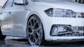 White car being washed with foaming soap