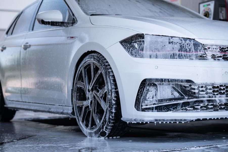 White car being washed with foaming soap