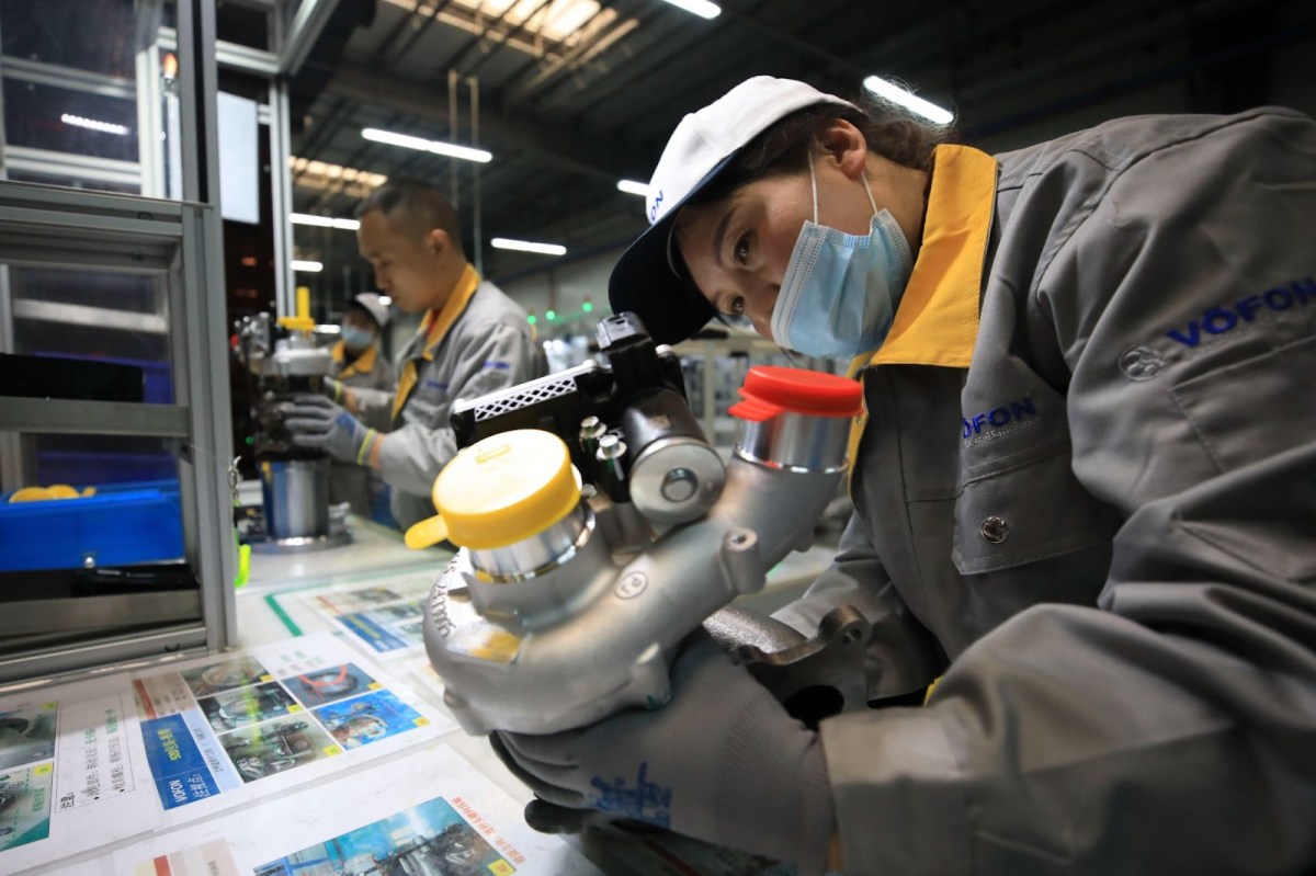 A worker inspects a turbocharger