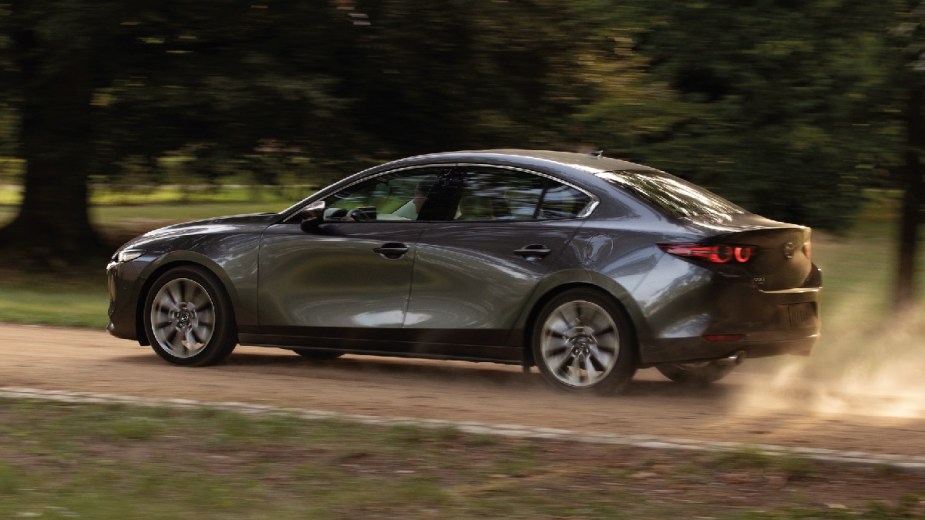 Gray 2023 Mazda3 compact car driving along a rough road