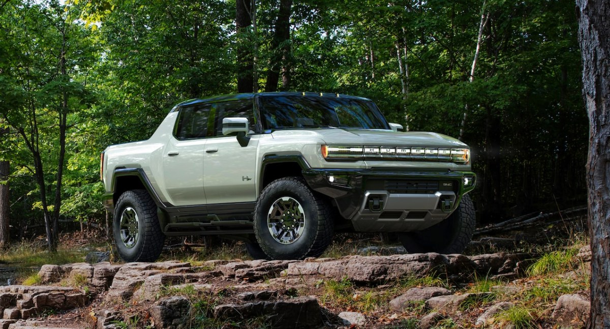 A green 2023 GMC Hummer EV electric pickup truck is parked outside.