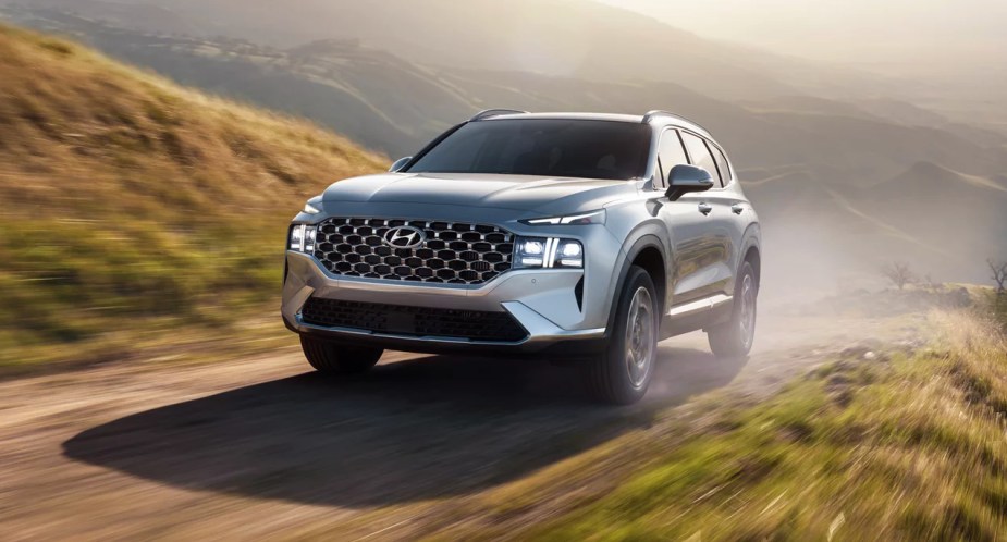 A gray Hyundai Santa Fe Plug-In Hybrid midsize plug-in hybrid SUV is driving off-road. 