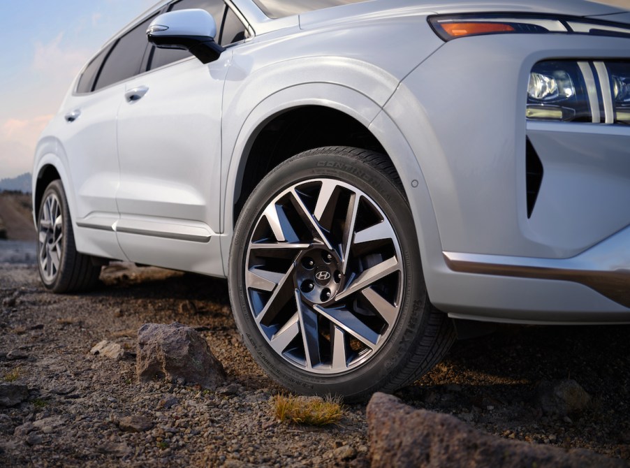 A white Hyundai Santa Fe, which is one of the best midsize plug-in hybrid SUVs parked outdoors.