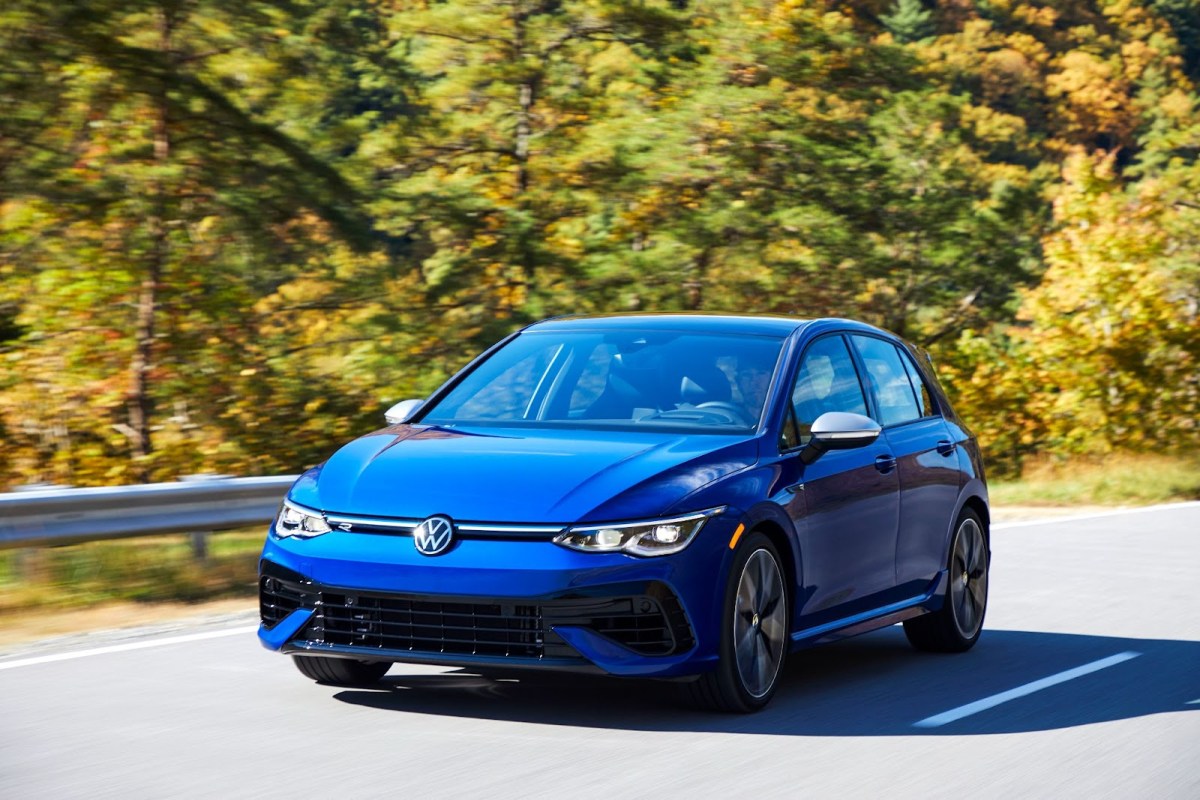 A blue Volkswagen Golf R driving down a road.