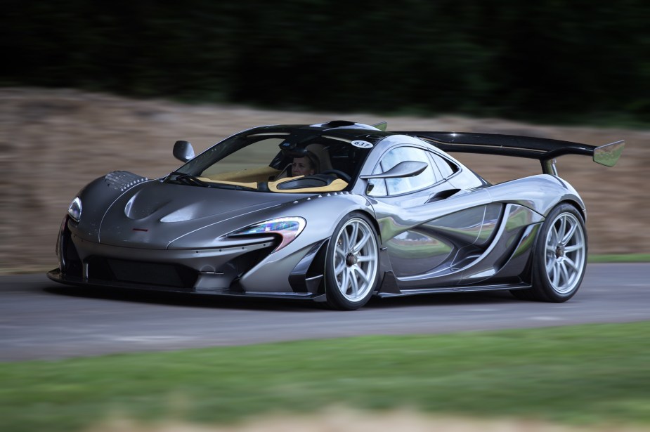 A McLaren P1 blasts up a hill climb, promising speed like a Ferrari SF90. 