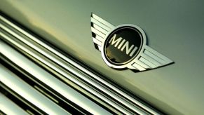 A logo on the front of a Mini Cooper. Finding a reliable Mini Cooper that's used can be difficult at times.