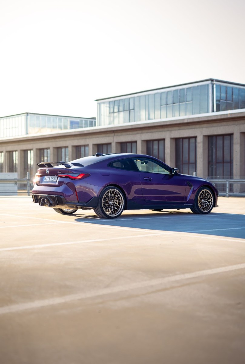 A purple BMW M4 Competition with bronze mesh wheels