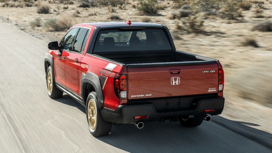 Rear angle view of red 2023 Honda Ridgeline midsize pickup truck