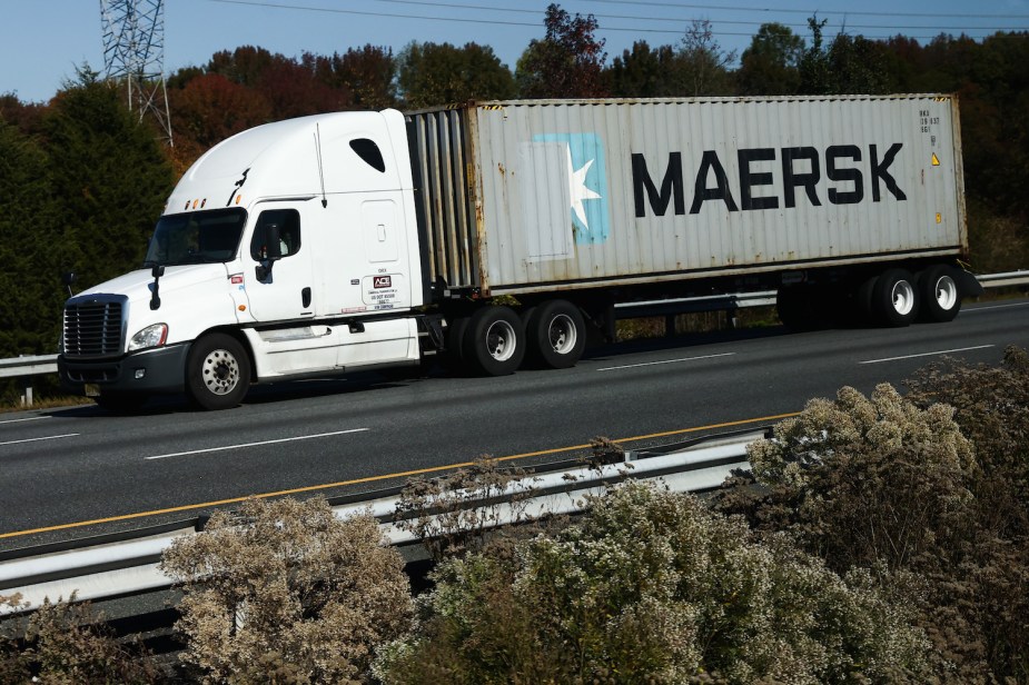 A semi truck using an engine brake to stop on a deserted highway.