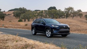 A used Toyota RAV4 Hybrid parks on a gravel road.