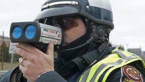 An officer uses a radar gun.