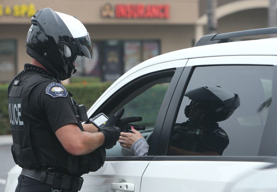 A cop writes a driver a ticket.