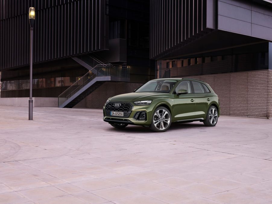 A green Audi Q5 compact luxury SUV parked near a lamppost