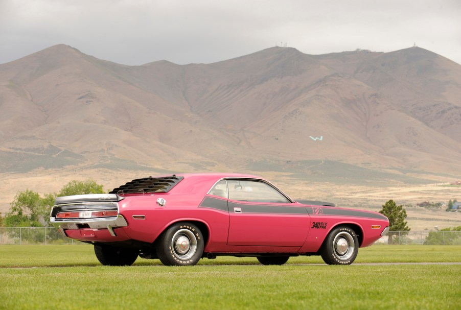 Reddish pink 1970 Dodge Challenger rare T/A Trans America trim parked in front of a mountain ridge.