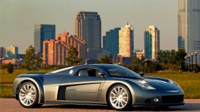 A two seat, mid-engine supercar concept by Chrysler is parked on a cobblestone street, a city's skyline visible in the background.