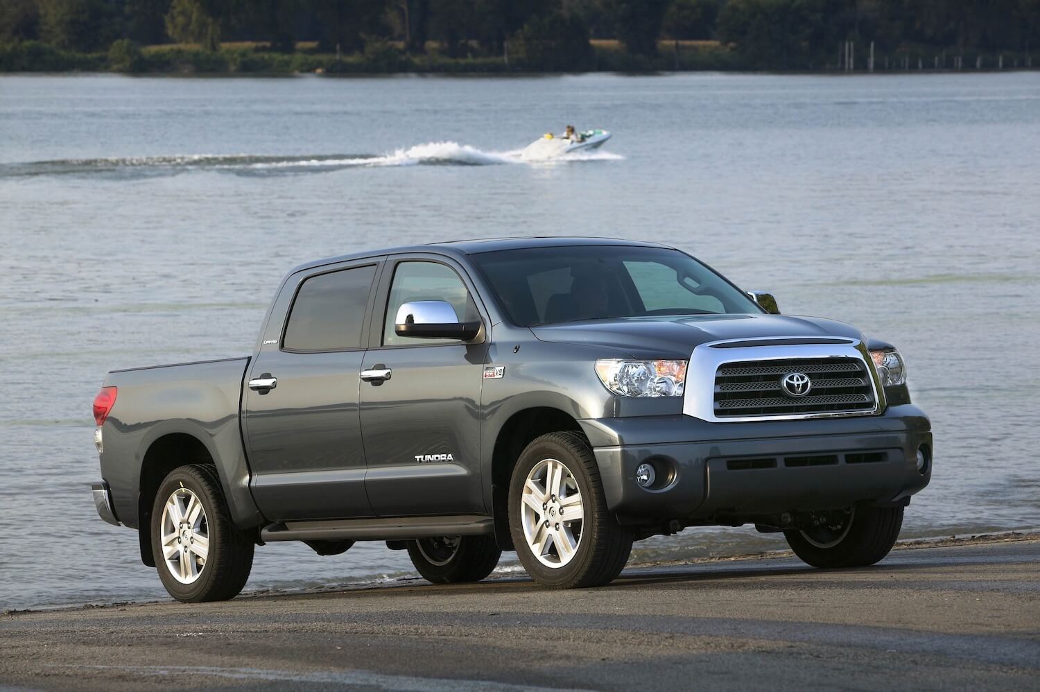 A gray four-door Toyota Tundra parked on a boat ramp, a jet ski visible in the background.