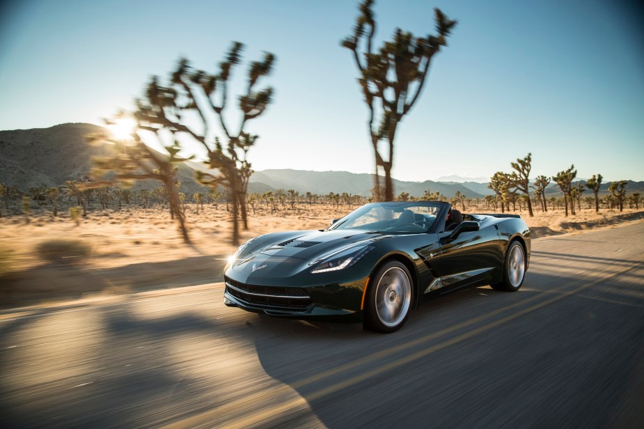 A 2014 Chevrolet Corvette Stingray Convertible cruises down a desert road with the top down.