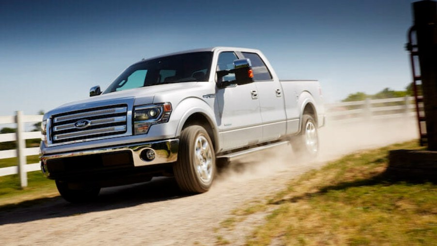 White 2014 Ford F-150 on a dirt road at a farm